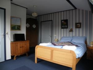 スロースケルケにあるB & B Eindelingeのベッドルーム(ベッド1台、ドレッサー内のテレビ付)