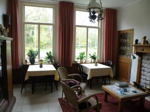 a dining room with two tables and a large window at B & B Eindelinge in Serooskerke