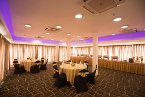 a banquet room with tables and chairs and curtains at GSH Colombo in Colombo