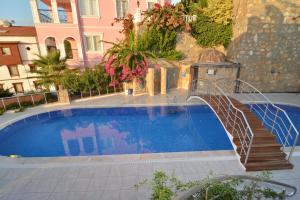 a swimming pool with a staircase next to a building at Villa Konak in Konaklı