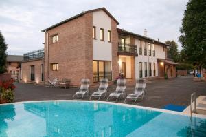 a swimming pool with chairs in front of a building at Anita Home in Gyenesdiás