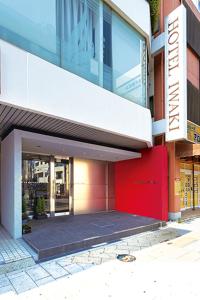 Hotel Iwaki في إيواكي: مبنى عليه باب احمر وعلامة عليه