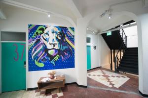 a painting of a lion on a wall in a hallway at Cacha Bed in Bangkok