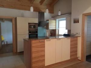 a kitchen with wooden cabinets and a stove top oven at Haus Tschirgantblick in Tarrenz