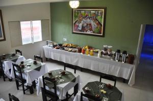 a dining room with two tables with white tableclothsurrencyangering at Hotel Oriente in Itajubá