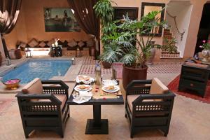 Riad Djemanna في مراكش: غرفة معيشة مع طاولة ومسبح