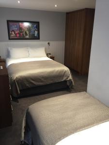 a hotel room with two beds and a cabinet at Carlton Hotel in Ilfracombe
