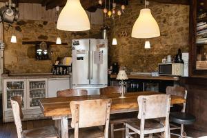 a kitchen with a wooden table and a refrigerator at Le Moulin de Planiol in Le Vigan