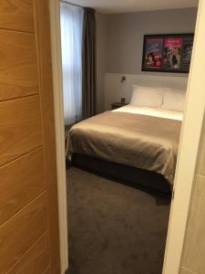 a small bedroom with a bed and a window at Carlton Hotel in Ilfracombe