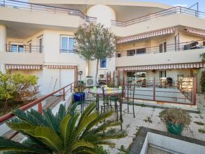 un immeuble d'appartements avec une terrasse et une table dans l'établissement Welkeys Apartment - Lanterne, à Nice