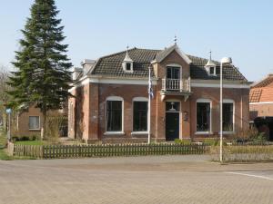 a brick house with a flag in front of it at B & B Eindelinge in Serooskerke