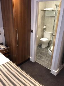a bathroom with a toilet and a glass shower at Carlton Hotel in Ilfracombe