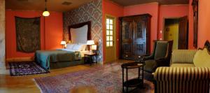 1 dormitorio con paredes de color naranja, 1 cama y 1 sofá en Writers' House Residency, en Tiflis