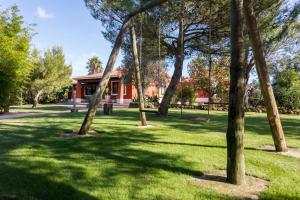 um grupo de árvores num parque com um edifício vermelho em Quinta da Alquimia em Lagos