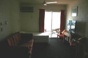 a living room with a couch and a bed and a television at Luma Luma Holiday Apartments in Darwin