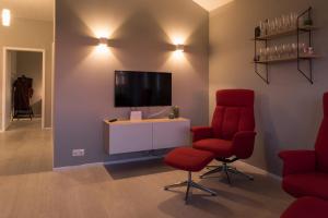 uma sala de estar com duas cadeiras vermelhas e uma televisão em Bryggjur em Hvolsvöllur