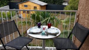 a table with plates and glasses on a balcony at Chambre 1 PERSONNE et STUDIO 1 personne Avec Entrée Libre et Salle de Bain Privée in Colomiers