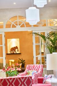 una hall con divani rosa e un dipinto di un orso di Hotel Boutique Corral del Rey a Siviglia