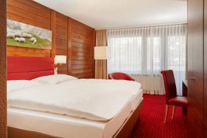 Postel nebo postele na pokoji v ubytování H+ Hotel & SPA Engelberg