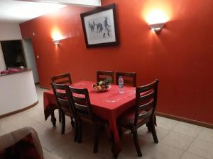 a red table with chairs and a red wall at Flo Villa in La Gaulette