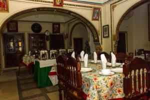 RāmgarhNarayan Niwas Castle的房间里有一张桌子和几把椅子的餐厅