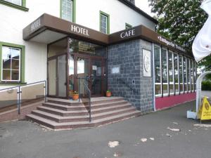 a hotel building with stairs in front of it at Hotel & Ristorante Positano in Radeburg