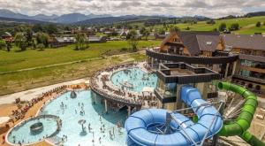an indoor water park with a large swimming pool at Toporowe Domki w Chochołowskiej in Witów
