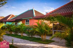 a house with a red roof and some palm trees at New Papa Pippo Resort in Sihanoukville