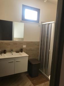 a bathroom with a sink and a window on the wall at Casa vacanze le Egadi Marsala in Marsala