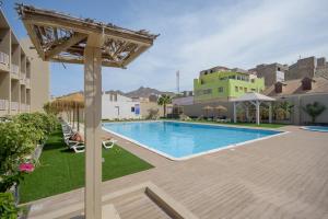 a swimming pool in a courtyard of a building at Oasis Porto Grande in Mindelo