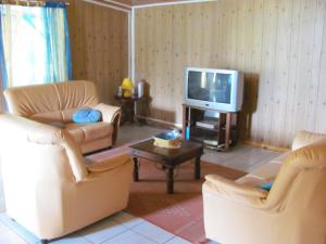 a living room with two couches and a tv at Les Bungalows du Mont-Auban in Sainte-Clotilde