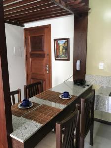 comedor con mesa, sillas y puerta en Apart Rei Barra, en Salvador