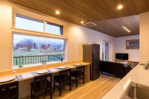 a large kitchen with a large window and a large island at Hakuba Downtown Apartments in Hakuba
