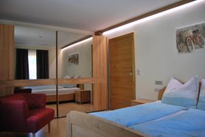 ein Hotelzimmer mit einem Bett und einem Stuhl in der Unterkunft Landresidenz s'Daham in Heiligenblut