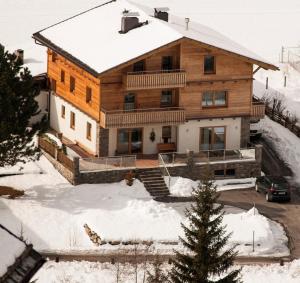 a house in the snow with a car in front at Landresidenz s'Daham in Heiligenblut