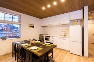 a large kitchen with a table and a refrigerator at Hakuba Downtown Apartments in Hakuba