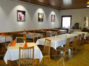 a restaurant with tables and chairs with white tablecloths at Bayerischer Hof in Heiligenberg