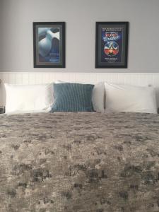 a bedroom with two pictures on the wall and a bed at Carlton Hotel in Ilfracombe