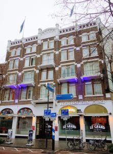 un gran edificio de ladrillo con luces moradas. en Grand Hotel Central, en Róterdam