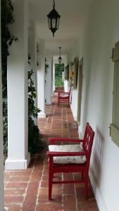 korytarz z dwoma czerwonymi ławkami w budynku w obiekcie Maison Cirmi w mieście Szabadhidvég
