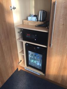 a kitchen with a cupboard with water bottles in it at Carlton Hotel in Ilfracombe