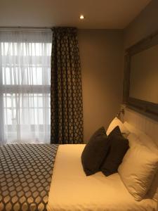 a bedroom with a bed with pillows and a window at Carlton Hotel in Ilfracombe