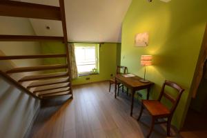 HerveにあるLes Coteaux du Vinaveのテーブルと椅子、階段が備わる客室です。