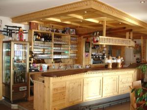 a bar with wooden cabinets and a refrigerator at Panorama Restaurant Sterzingerhaus 1.930m in Vipiteno