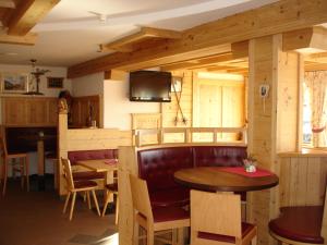 a dining room with a table and chairs and a tv at Panorama Restaurant Sterzingerhaus 1.930m in Vipiteno