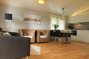 een woonkamer met een bank en een tafel met stoelen bij Cozy Cottage in Warmenhuizen