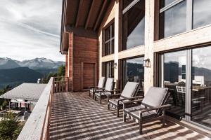 una terraza con sillas en una casa con montañas en Chalet Kristall, en Rosswald
