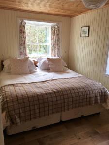 a bed in a room with a window at Glenbranter Cottage in Strachur