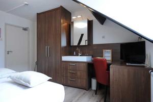 a bedroom with a bed and a sink and a mirror at Hotel De Oude Brouwerij in Mechelen