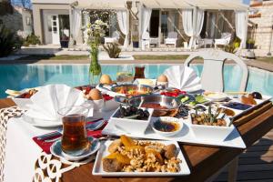 uma mesa com comida e bebidas junto a uma piscina em Sade Alacati Hotel em Alacati